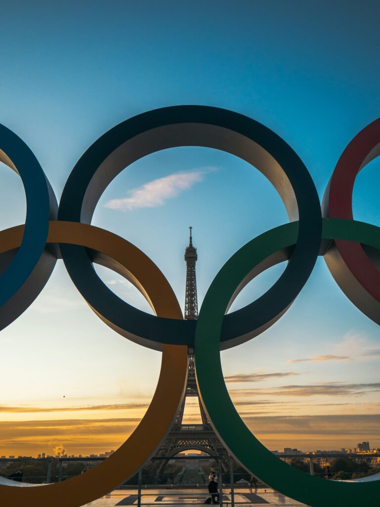 Anneaux olympiques avec Tour Eiffel en arrière plan - Gagner en visibilité grâce aux événements sportifs - AVICOM'